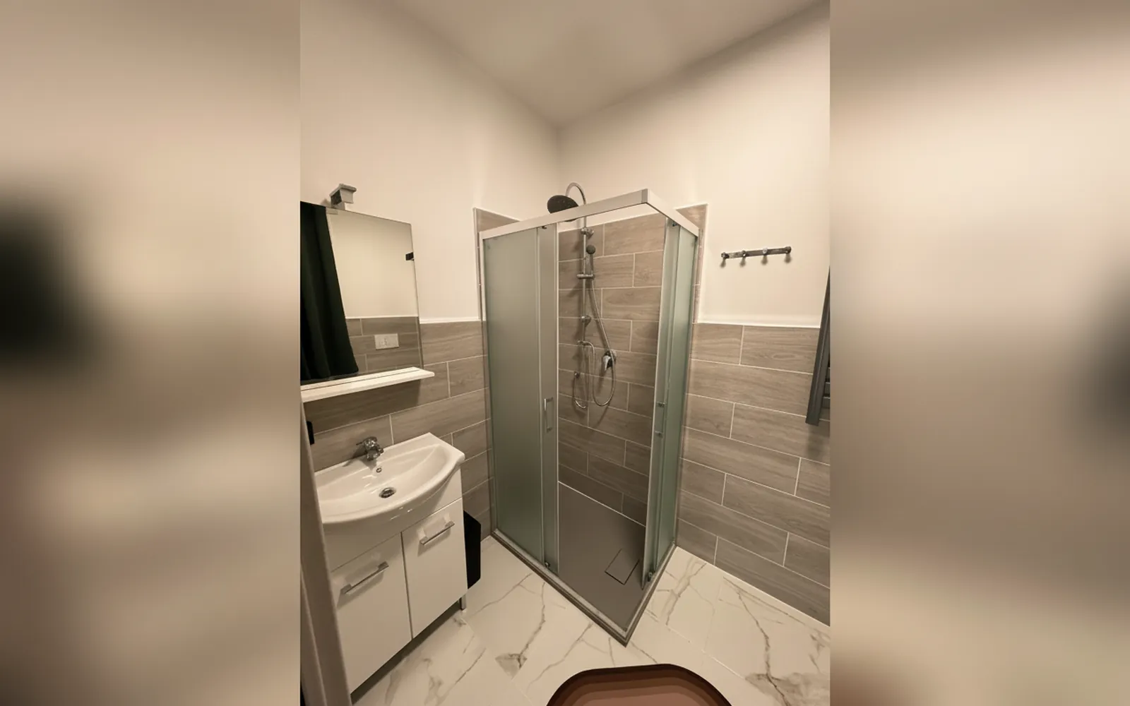 Il bagno privato con il lavabo e il box doccia