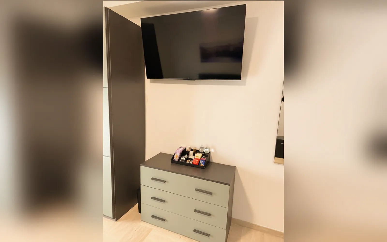 La cassettiera con il vassoio di benvenuto e la TV a parete